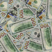 Scattered Full Print New Series $100 prop bills showing fronts and Independence Hall backs