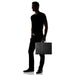Person carrying the closed black briefcase to show its size