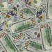 Actual Full Print $100 prop bills scattered together, showing the reverse design and motion picture markings